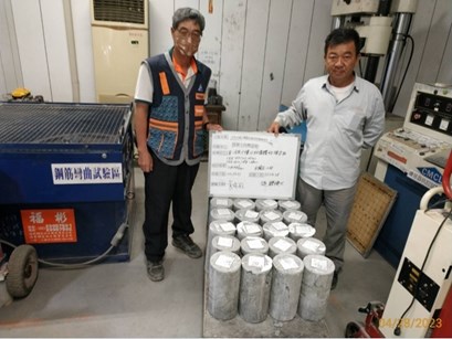 二人拿取混凝土抗壓試驗標示板
