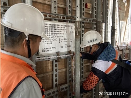 二人拿模板查驗標示板